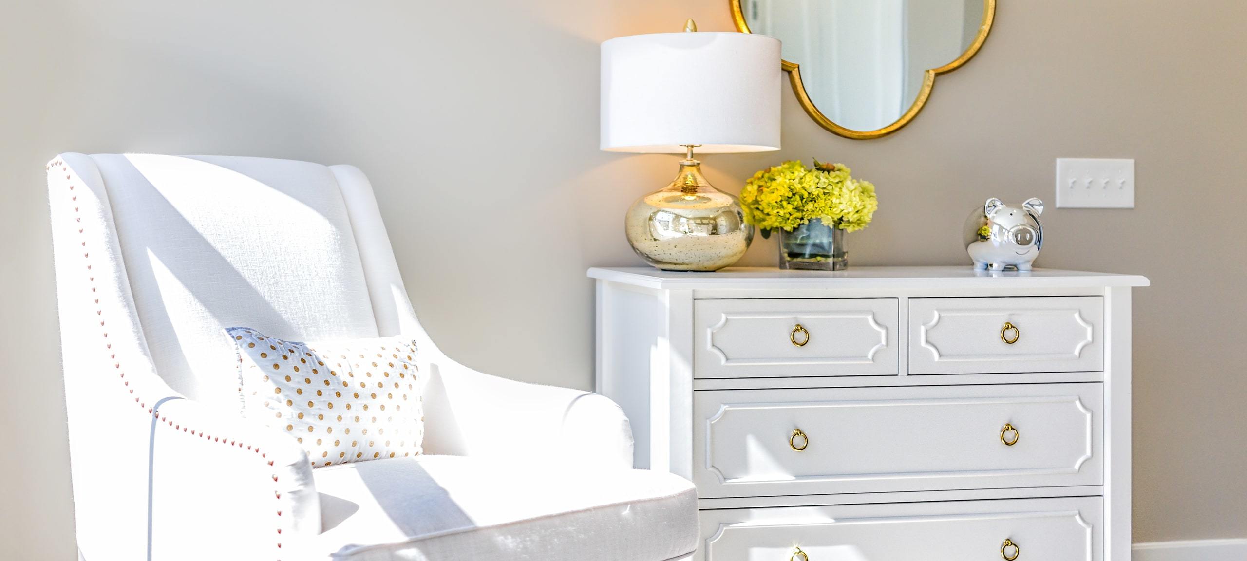 Staged nursery with white chair and table, typical of Decatur, IL